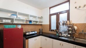 A kitchen with white cabinets, a red refrigerator, a stove, and a sink. - Villa Kartina 3 BHK near Sattal Lake (Bhowāli)