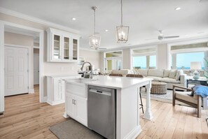 Una cucina spaziosa con isola centrale, mobili bianchi e un rubinetto moderno.