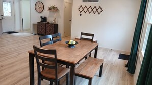 Un comedor con una mesa de madera, cuatro sillas y un adorno decorativo.