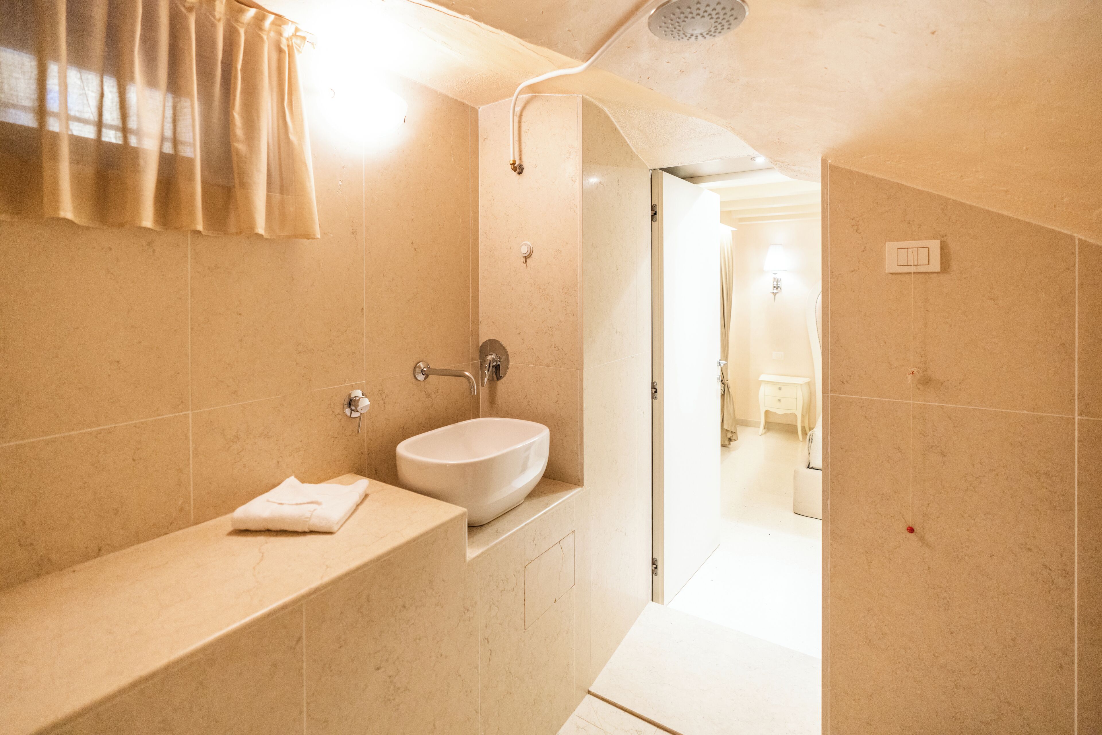 A modern bathroom with a sink, mirror, and shower.