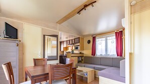 Un espacio habitable compacto con comedor, kitchenette y zona de estar.