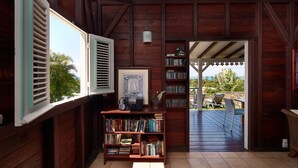 Un interior de fusta amb una biblioteca, un quadre amb marc i vista a l'exterior.