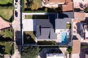 An aerial view of a residential area with a swimming pool, tiled roofs, and green spaces. - Apartment 'Athena' with Shared Pool, Wi-Fi and Air Conditioning (Fontane Bianche)