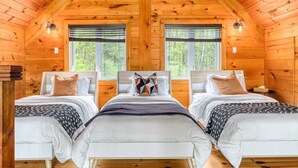 A cabin with two beds, wooden walls, and large windows. - Henö - Entre lac & forêt (Mandeville)