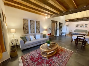 A cozy living room with a sofa, coffee table, and artwork on the walls. - Bed and Breakfast 'Olceiry' with Mountain View, Private Garden and Wi-Fi (Iholdy)