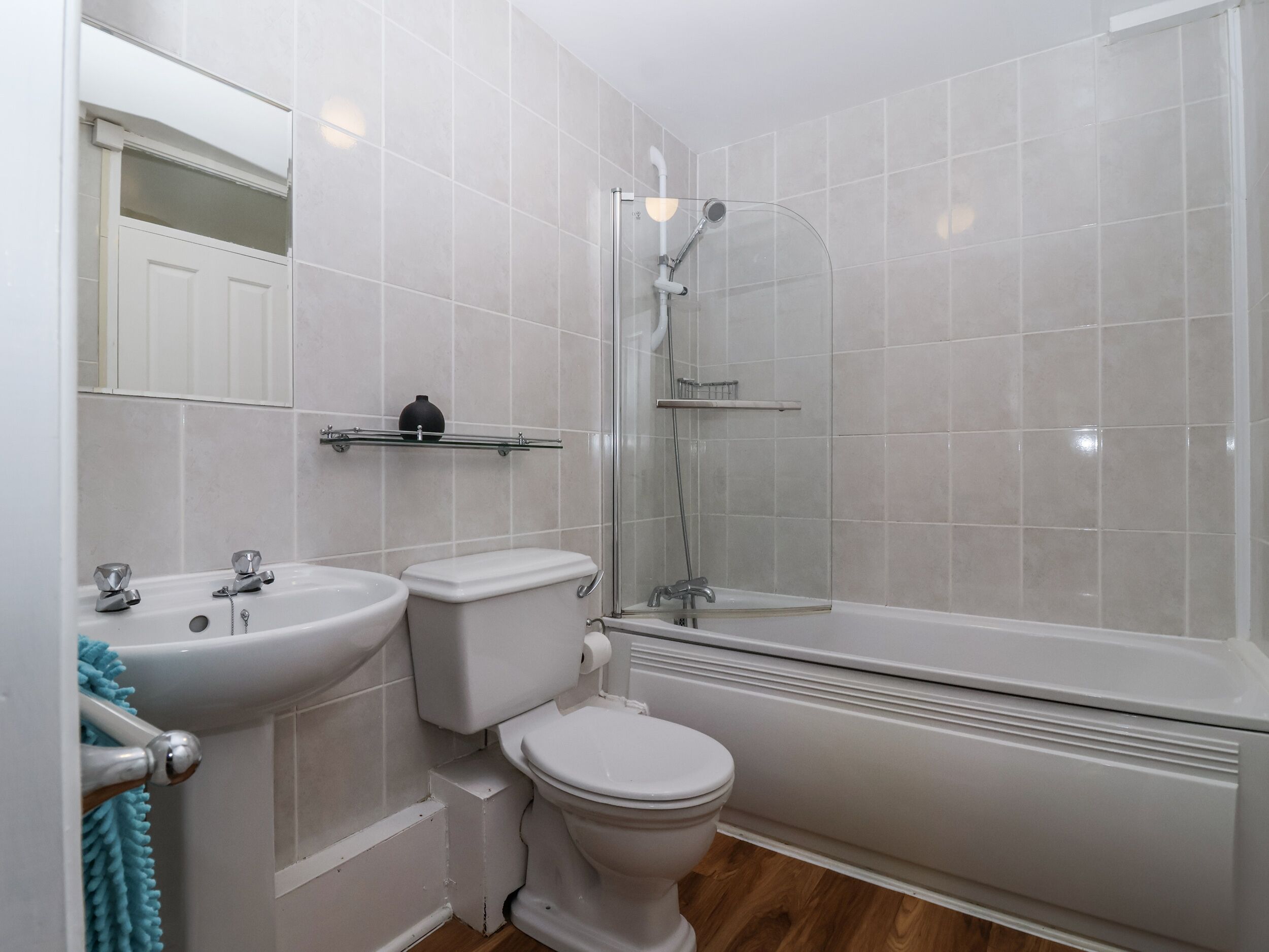 A bathroom with a toilet, sink, and shower.