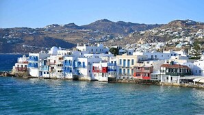 A coastal village with white buildings with blue accents, situated by the sea with a mountainous backdrop. - Casa Lakka 2 - Trendy Studio in Mykonos Town (Lakka Mikonos)