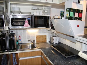 A kitchen with a microwave, toaster, sink, and a refrigerator. - Studio 'Jülich' with Private Terrace, Shared Garden and Wi-Fi (Weil am Rhein)