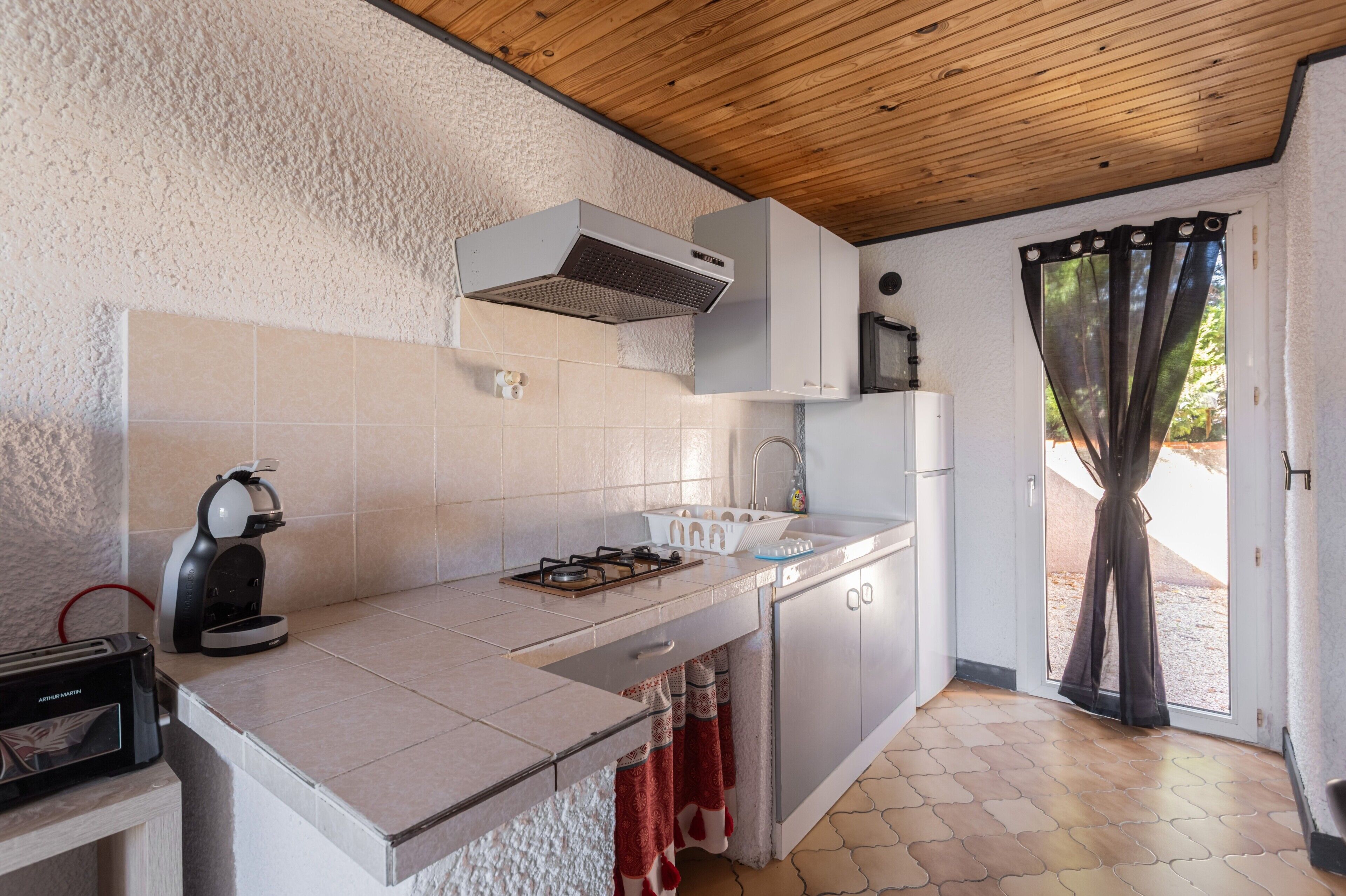 A kitchen with a gas stove, a coffee machine, and a dishwasher.