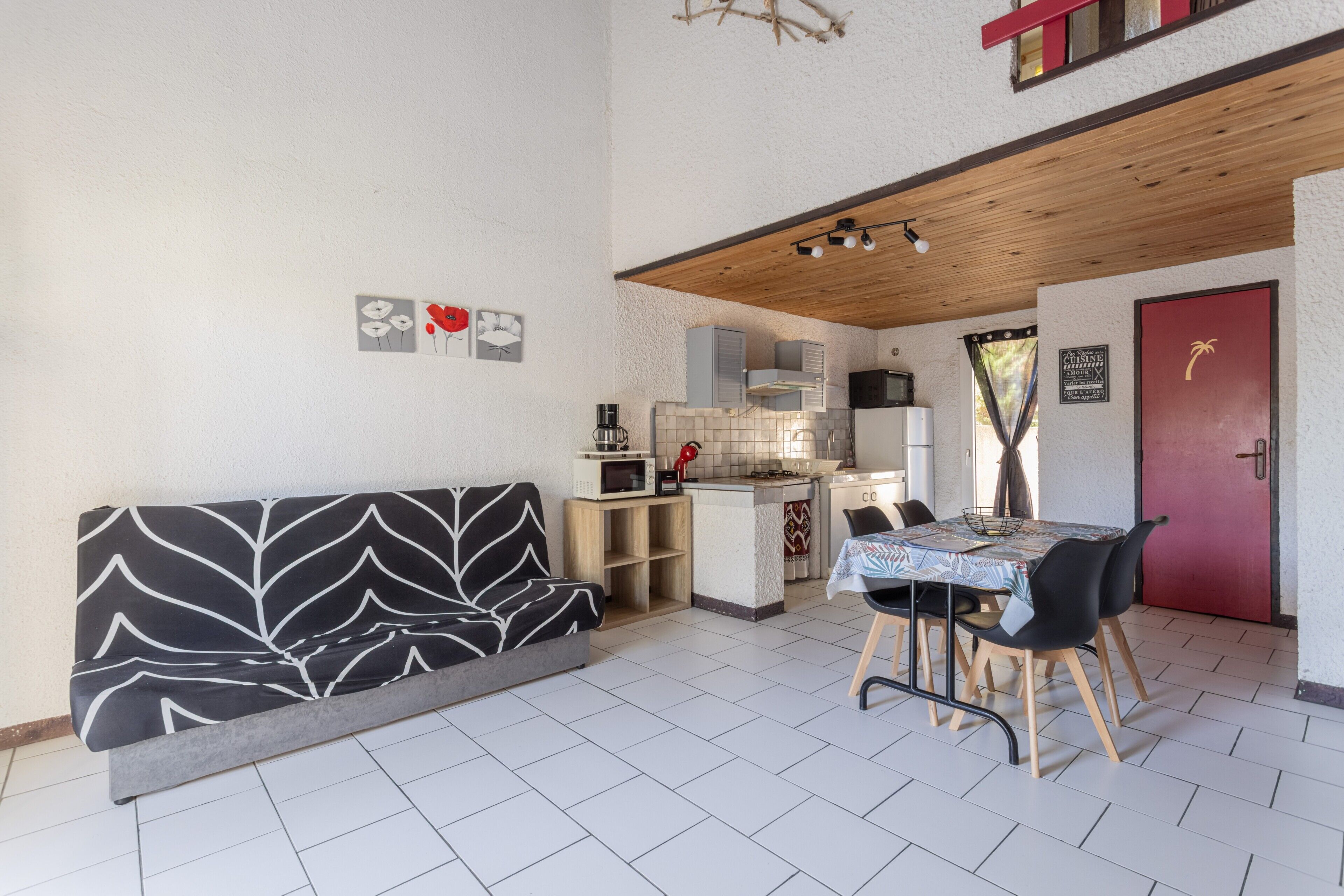 A compact living space with a sofa, dining table, and kitchenette.