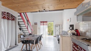 Eine geräumige Küche mit Essbereich, einer Treppe und Blick ins Freie.