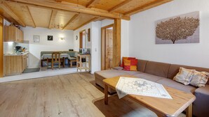 A wooden interior with a sofa, a table, and a dining area. - Apartment 1 with Shared Garden, Balcony and Wi-Fi (Todtmoos)