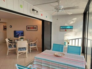 A dining area with a table and chairs, a ceiling fan, and a TV on the wall.
