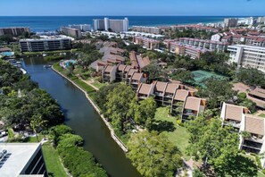 A coastal hotel with multiple buildings, a river, and a view of the ocean.
