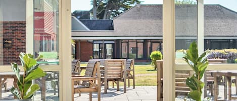 An outdoor seating area with wooden benches and potted plants.