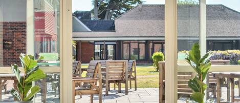 An outdoor seating area with wooden benches and potted plants.
