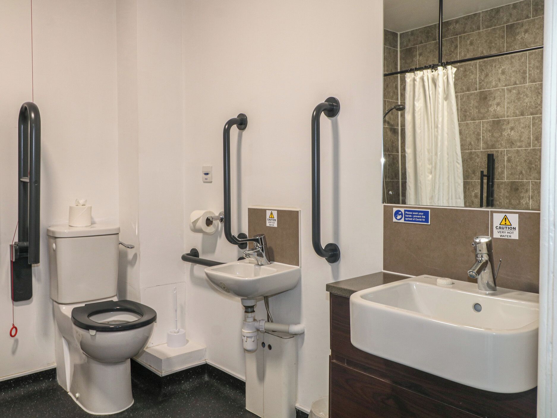 Une salle de bain comprenant des toilettes, un lavabo et un espace douche.