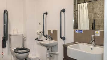 Une salle de bain comprenant des toilettes, un lavabo et un espace douche.