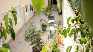 A courtyard with potted plants, a green chair, and a yellow bucket. - Bali apartment with patio - Le Mans, apartment with patio - Le Mans (Le Mans)