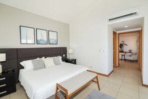 A bedroom with a large bed, bedside tables, a bench, and framed artwork on the wall. - Sleeps 10, Views & Beach 1 Block (Nuevo Vallarta)