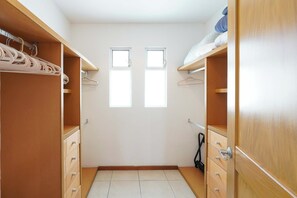 A walk-in closet with wooden shelving, a hanging rod, and two windows. - Sleeps 10, Views & Beach 1 Block (Nuevo Vallarta)