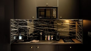 A modern kitchen with a black countertop, a microwave, and cabinets.
