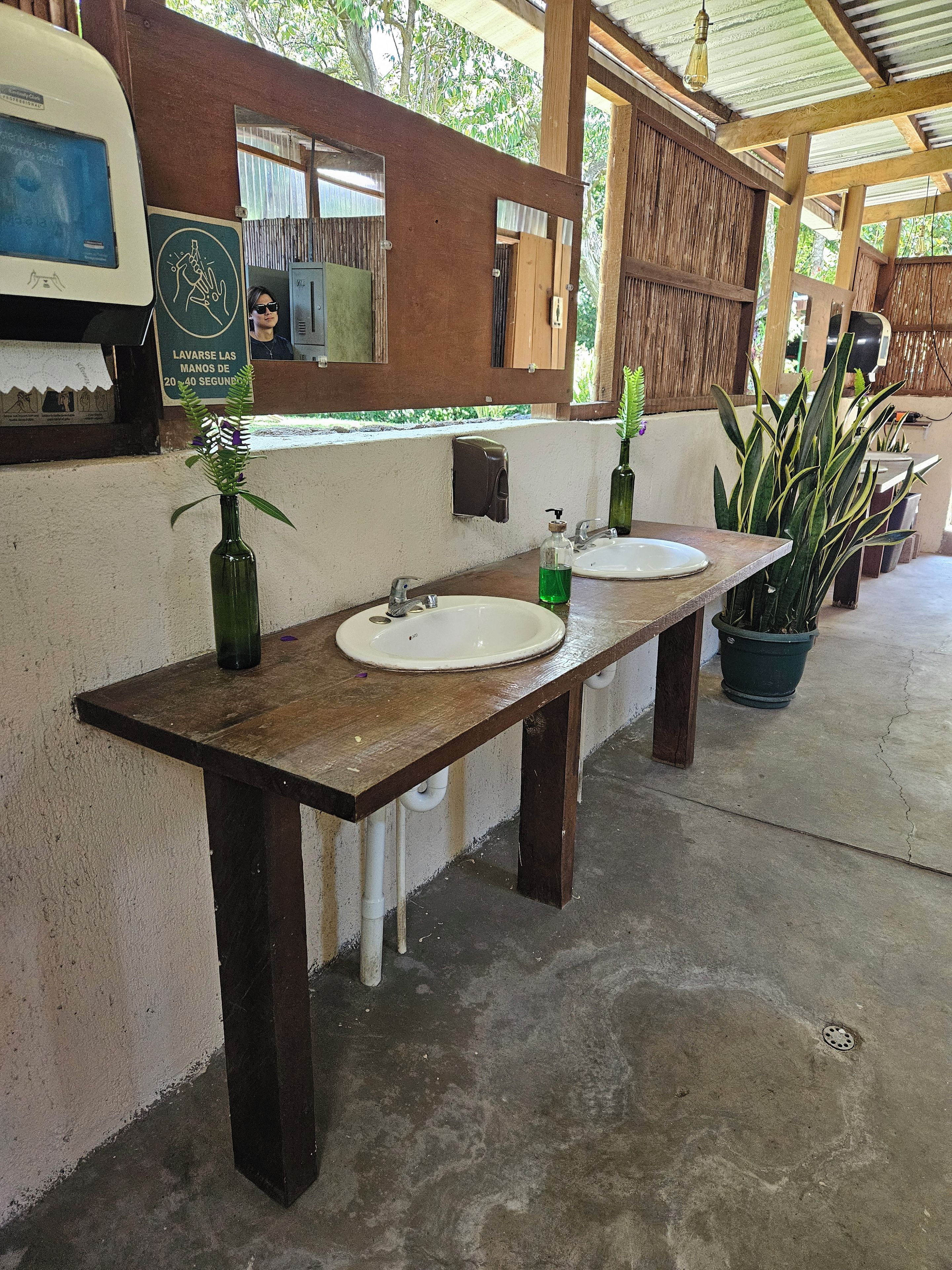 Casa de banho com duas pias, um espelho e dispensador de sabão.