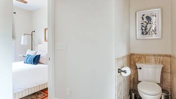 Una camera da letto con un letto, una lampada da comodino e un quadro appeso al muro.