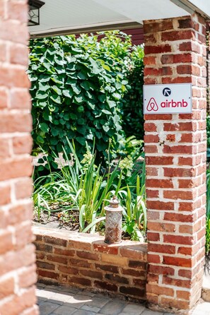 Pared de ladrillo con un letrero que indica una propiedad de Airbnb.