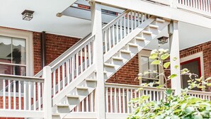 Een woongebouw met een witte trap die naar een balkon leidt.