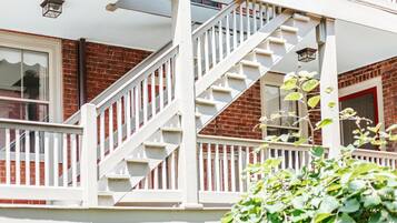 A residential building with a white staircase leading to a balcony.