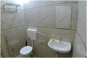 A bathroom with a toilet, sink, and shower.