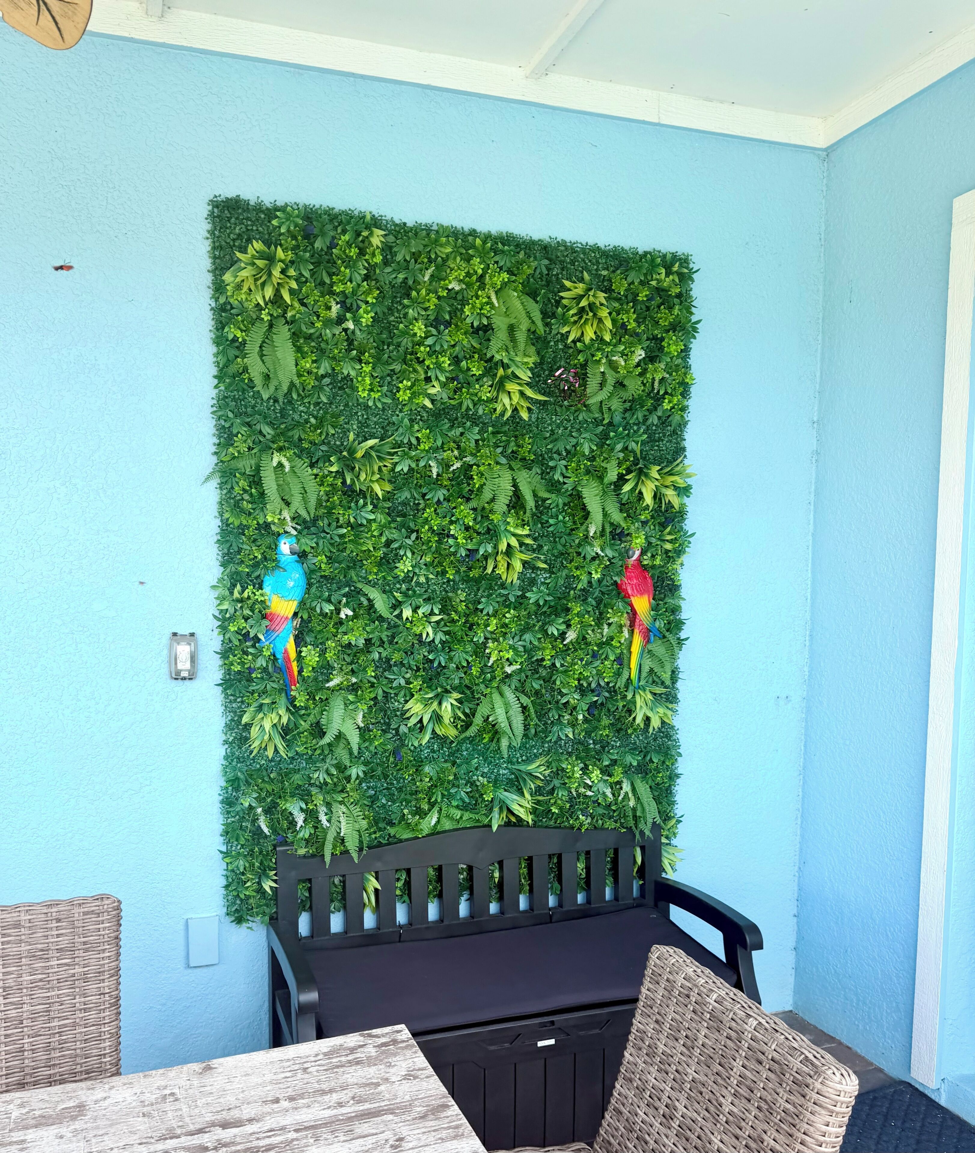 A room with a blue wall, a black bench, and a green wall panel.