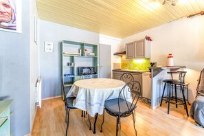 A compact kitchen with a dining table, chairs, and a microwave. - Apartment 'Terrace Pool' with Wi-Fi (Vallabrix)