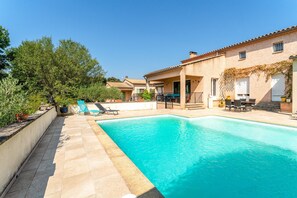 A swimming pool with a tiled deck, a patio area with outdoor furniture, and a building with a tiled roof. - Apartment 'Terrace Pool' with Wi-Fi (Vallabrix)