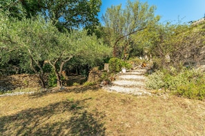 A stone pathway leading through a garden with trees and shrubs. - Apartment 'Terrace Pool' with Wi-Fi (Vallabrix)
