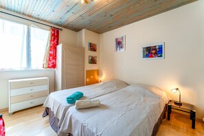 A bedroom with a bed, a nightstand, a dresser, a window with curtains, and wall art. - Apartment 'Terrace Pool' with Wi-Fi (Vallabrix)