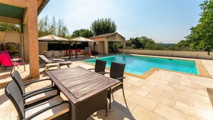 A pool area with lounge chairs, a table, and a covered seating area. - Apartment 'Villabrix Near Uzès' with Wi-Fi (Vallabrix)