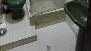 A bathroom with a glass-enclosed shower, a green toilet, and a green sink. - APARTAMENTO 1105T (Cartagena)