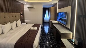 A modern hotel room with a large bed, a flat-screen TV, and a marble floor. - Presken Hotels Abuja (Abuja)