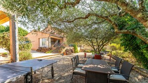 An outdoor patio with a ping pong table, wicker chairs, and a house in the background. - Holiday Home 'Obofix' with Wi-Fi (Vallabrix)