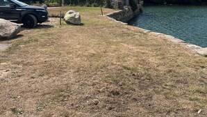 Un edificio de piedra con una torre, cerca de una masa de agua.