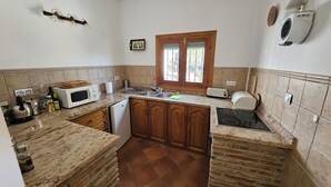 A compact kitchen with a microwave, toaster, and sink.