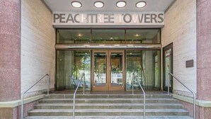L’entrée des immeubles Peachtree Towers se compose d’une porte en verre, d’un escalier et d’une enseigne placée au-dessus de la porte.