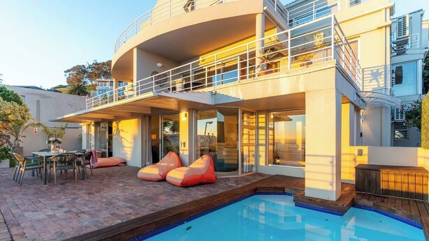 A modern house with a swimming pool, outdoor seating, and a balcony. - Your CT experience starts here (Cape Town)