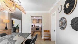 A dining area with a marble table, chairs, a lamp, and decorative wall art.
