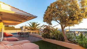 A rooftop terrace with a dining area, seating, and a view of the city. - Your CT experience starts here (Cape Town)