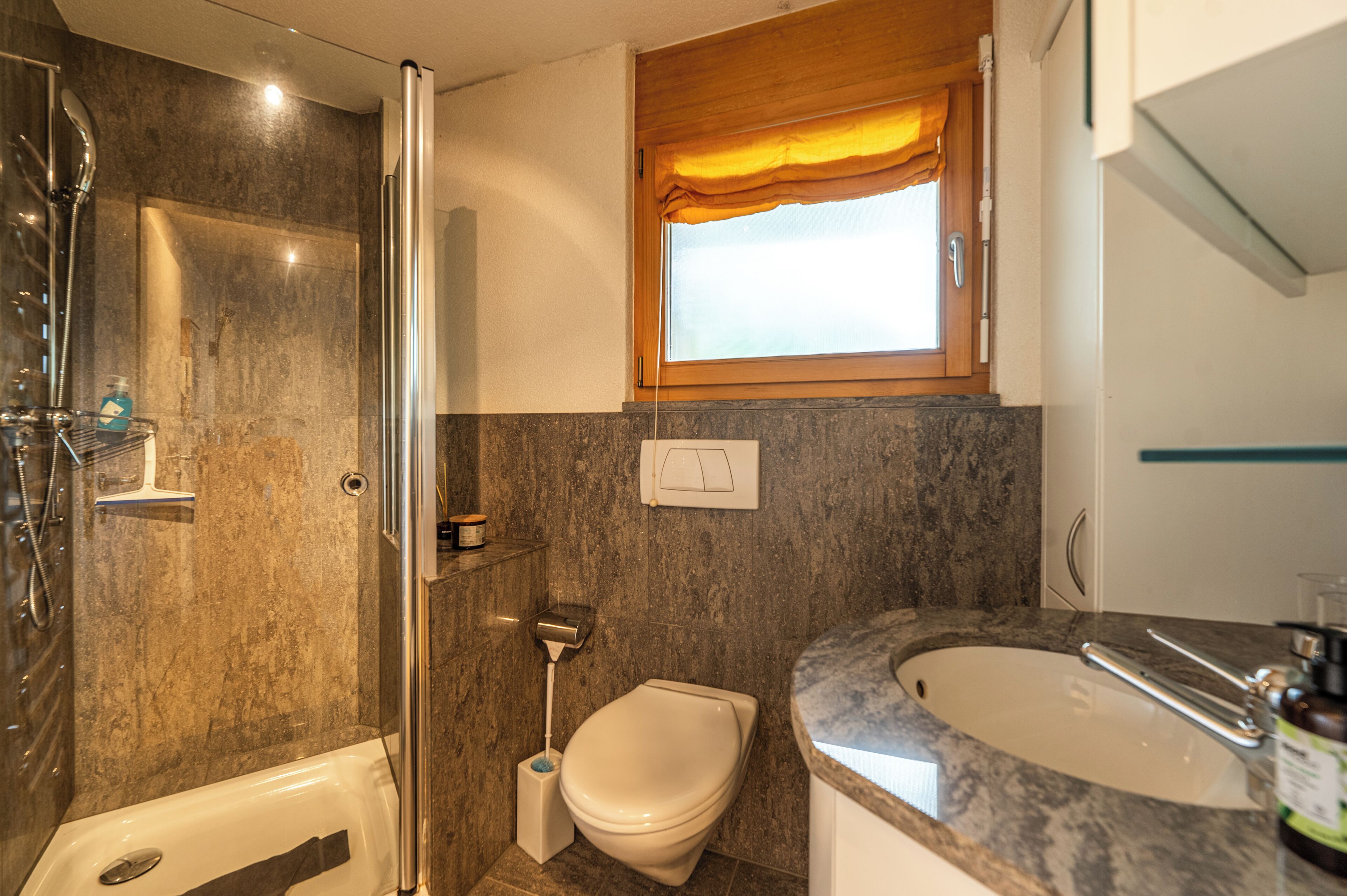 Un baño con ducha, inodoro y lavamanos.