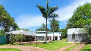 Un bâtiment moderne doté d’une cour intérieure, entouré d’une végétation luxuriante et de palmiers.