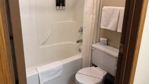 Ein Badezimmer mit Badewanne, Toilette und Duschvorhang.